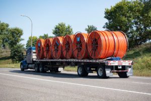 flatbed transporting large rolls of cable